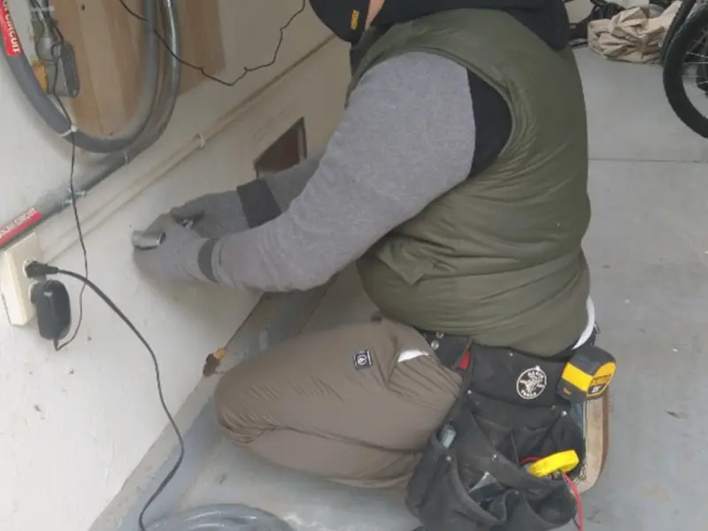 Electrician performing outlet wiring in a Banning garage